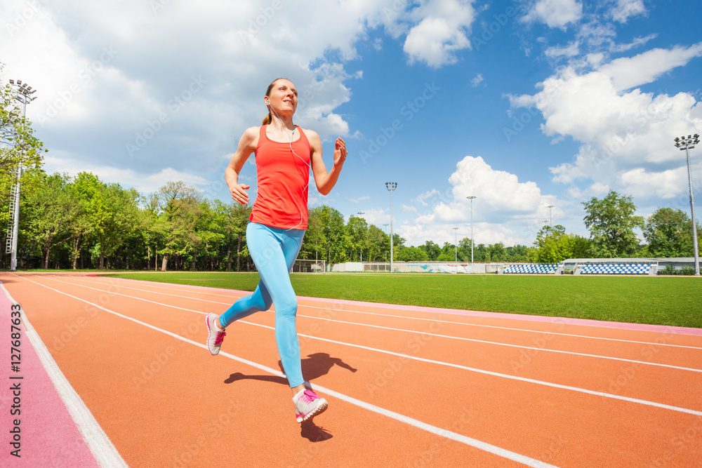 Active female runner working out at stadiums track