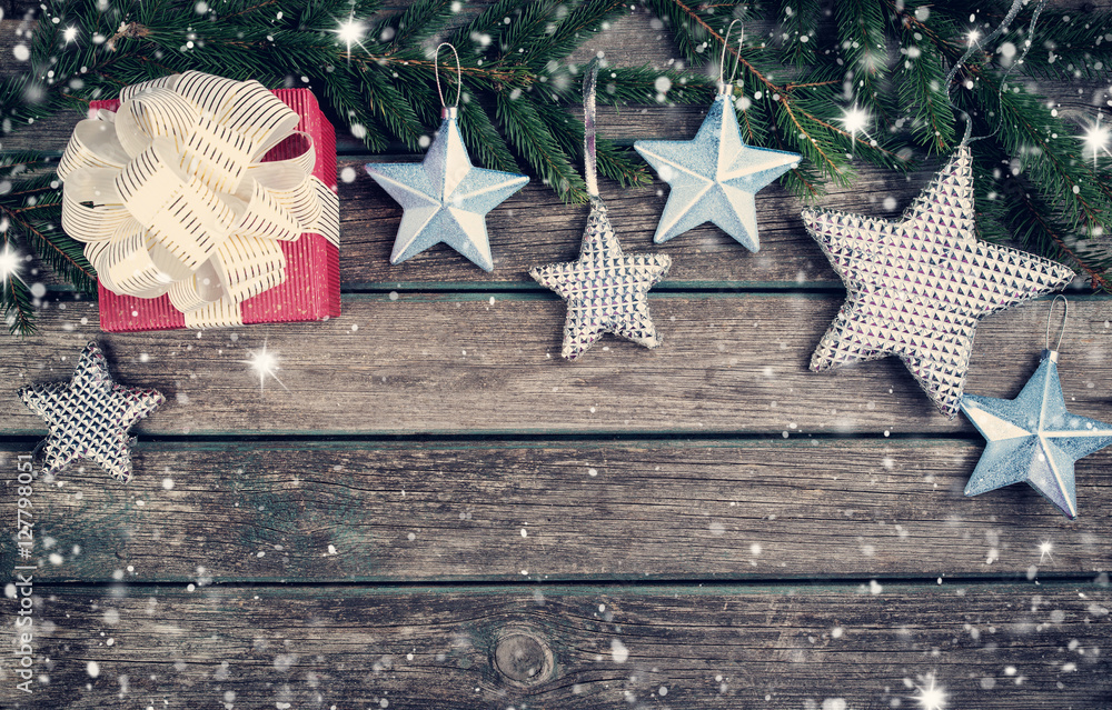 Christmas stars on wooden background with fir tree branches