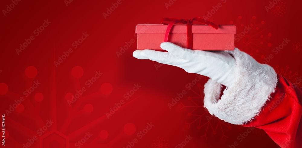 Composite image of santa claus holding gift box in hand