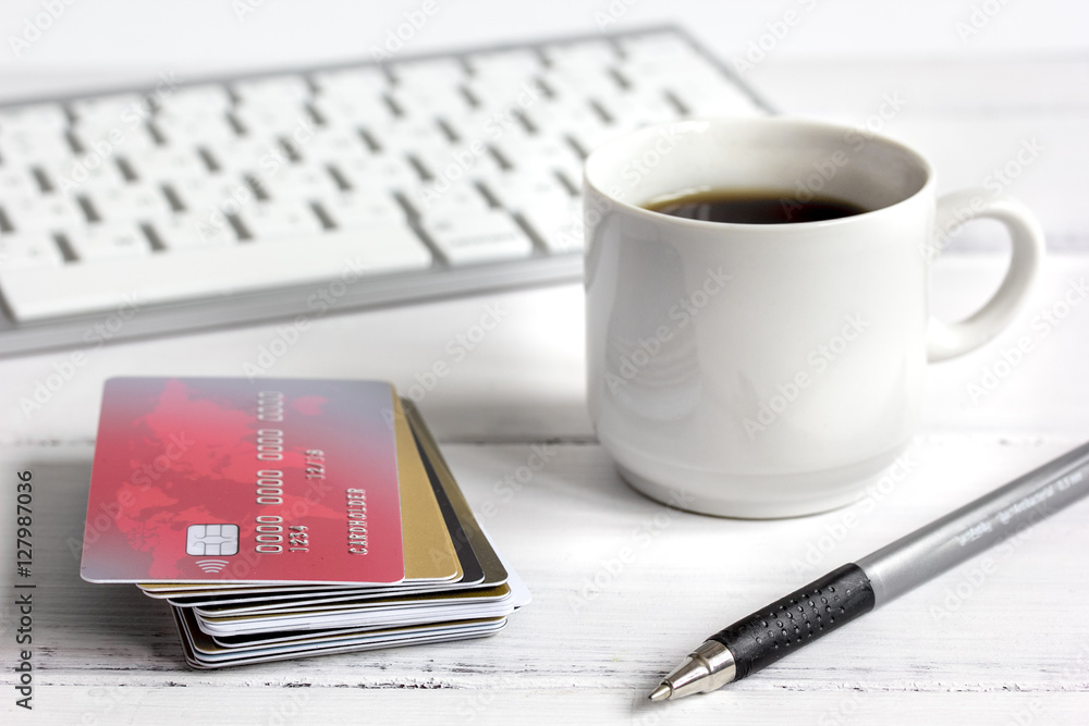 credit card, keyboard and coffee cup on wooden background