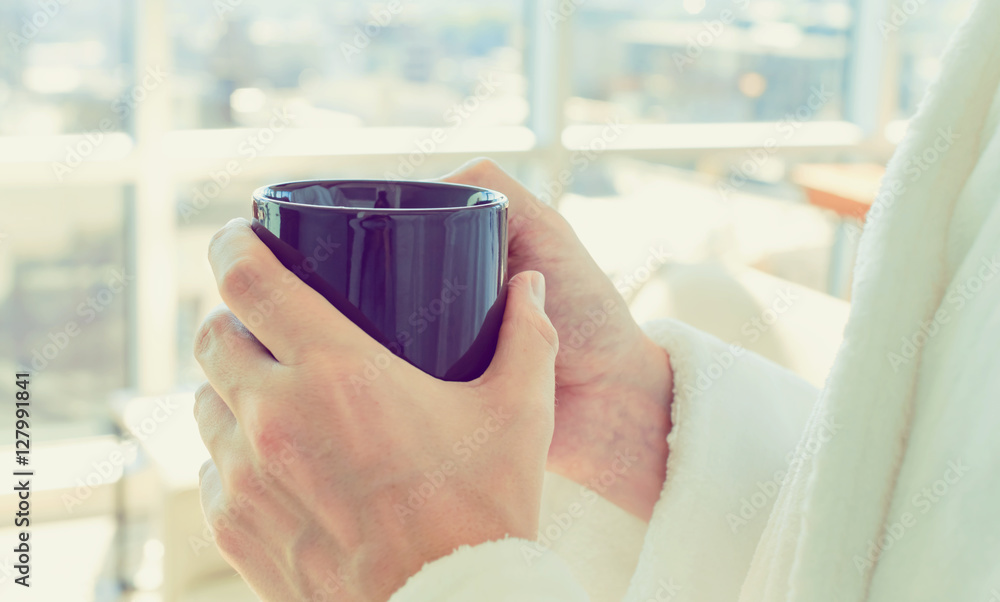 Man in a bathrobe with a cup of coffee