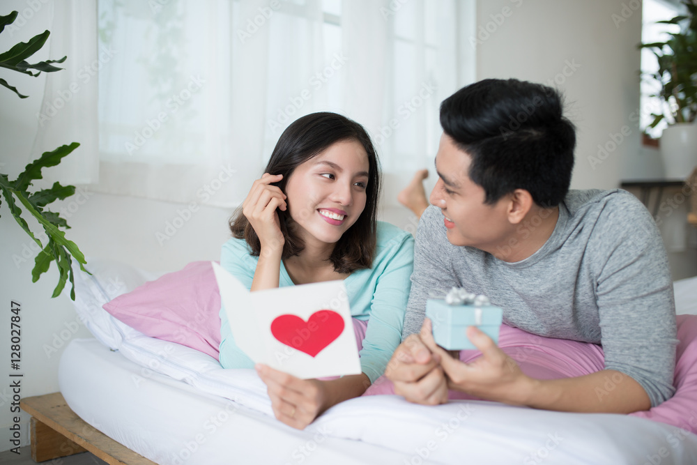 Young couple in love make a present to each other on Valentines