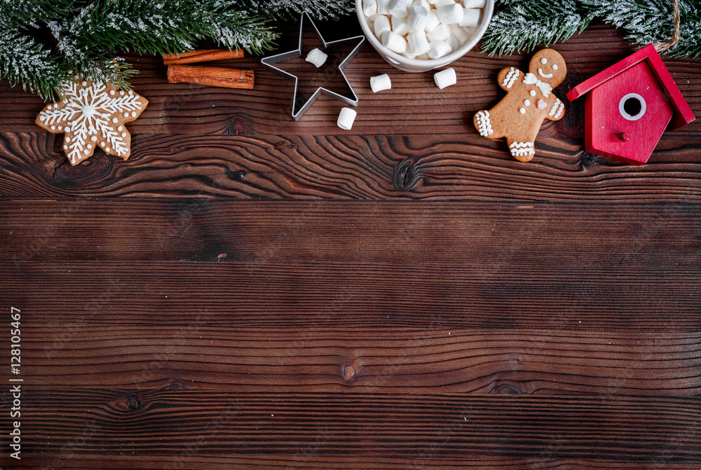 Christmas gingerbread, spruce branches on dark wooden background top view