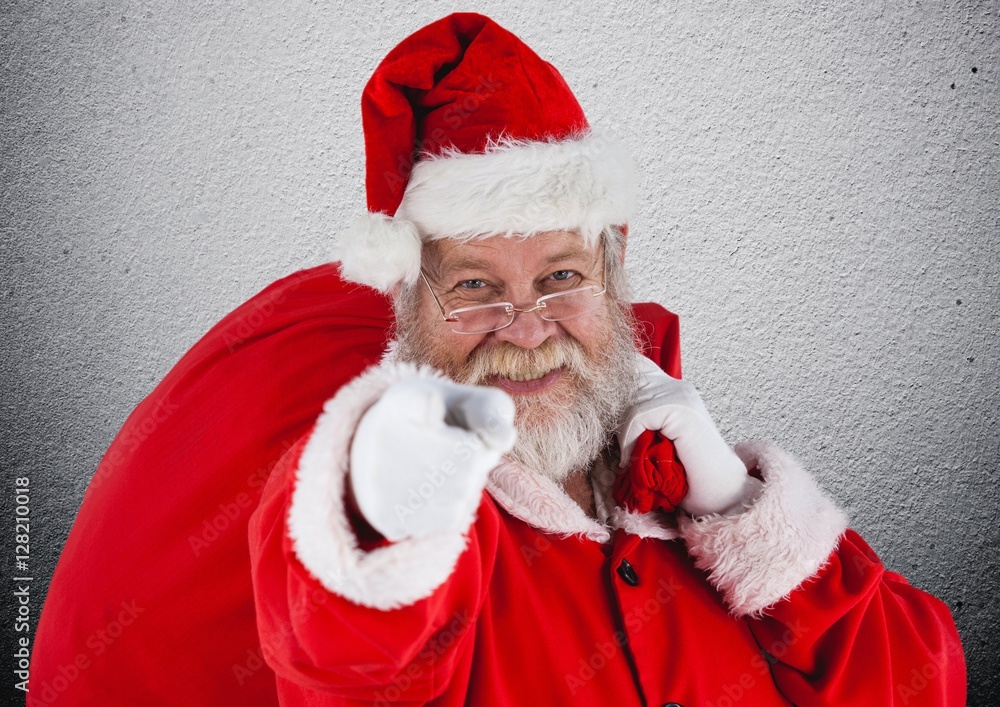 Santa claus with gift sack pointing towards camera