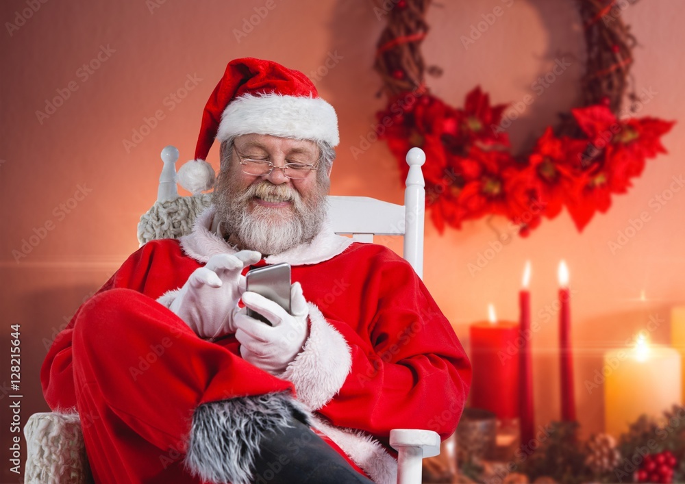 Happy santa sitting on chair and using mobile phone