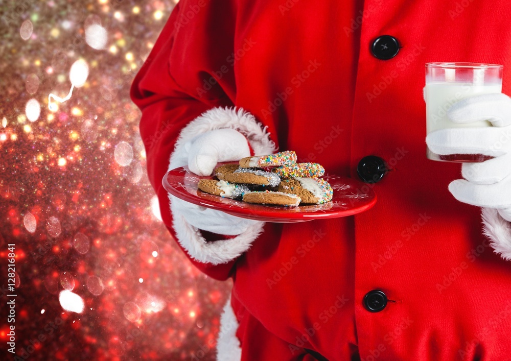 Santa hand holding cookies and a glass of milk