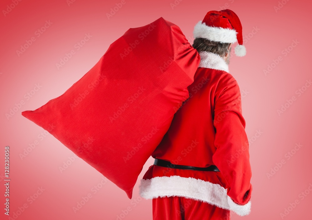 Santa claus holding gift bag standing against red background