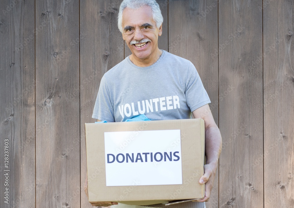 Smiling male volunteer holding donations box