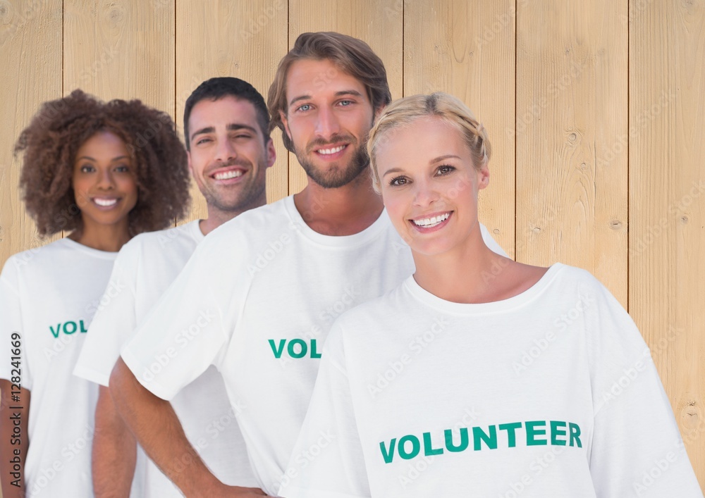 Group of volunteers standing against wooden background