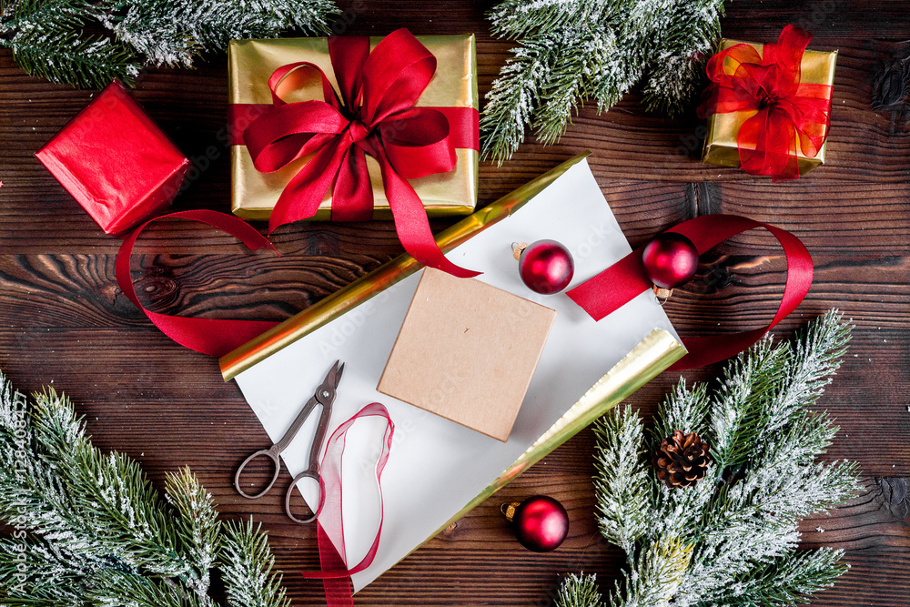 gifts boxes with fir branches on wooden background top view