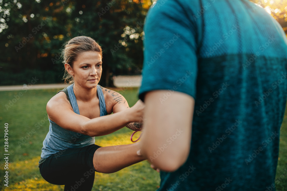 Fitness woman exercising with help of coach