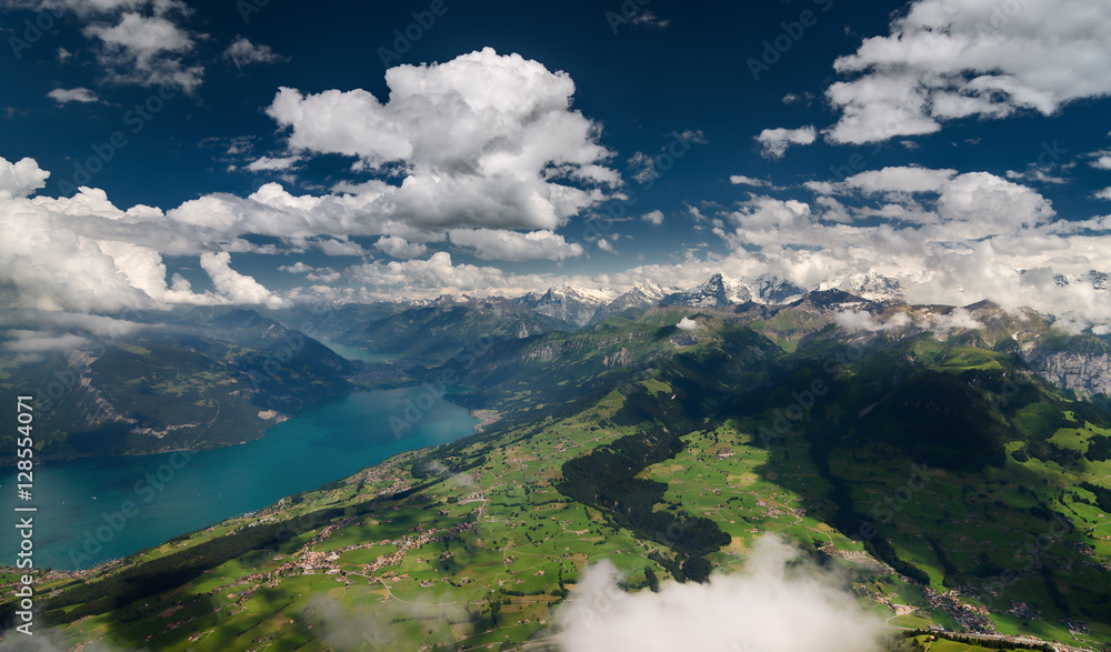 Aerial shot of Bernese Alps, lush valley and Lake of Thun, Berner Oberland, Switzerland.