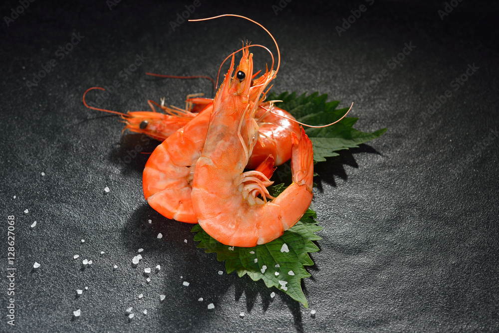 Cooked shrimps,prawns with seasonings on black stone background