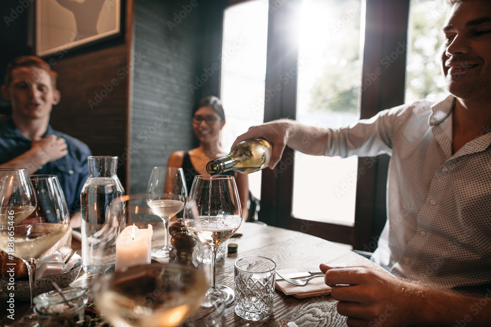 Group of young friends enjoying meal in restaurant