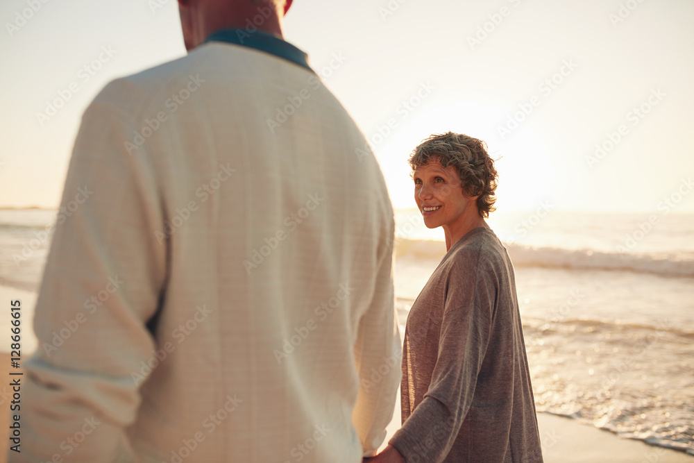 Mature couple walking together on sea shore