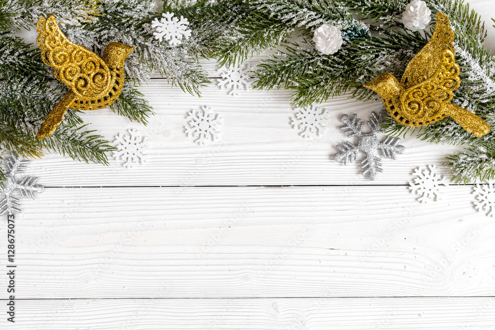 Christmas toys and spruce branches on wooden background top view