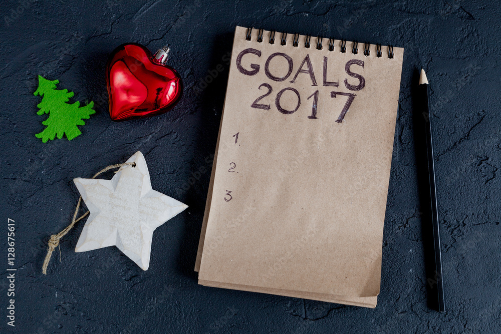 notebook and goals for new year dark background top view