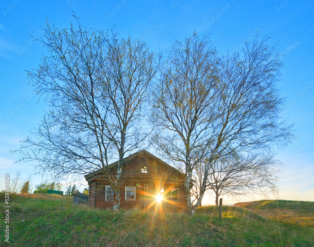 Abandoned village house and the sun in the broken window.