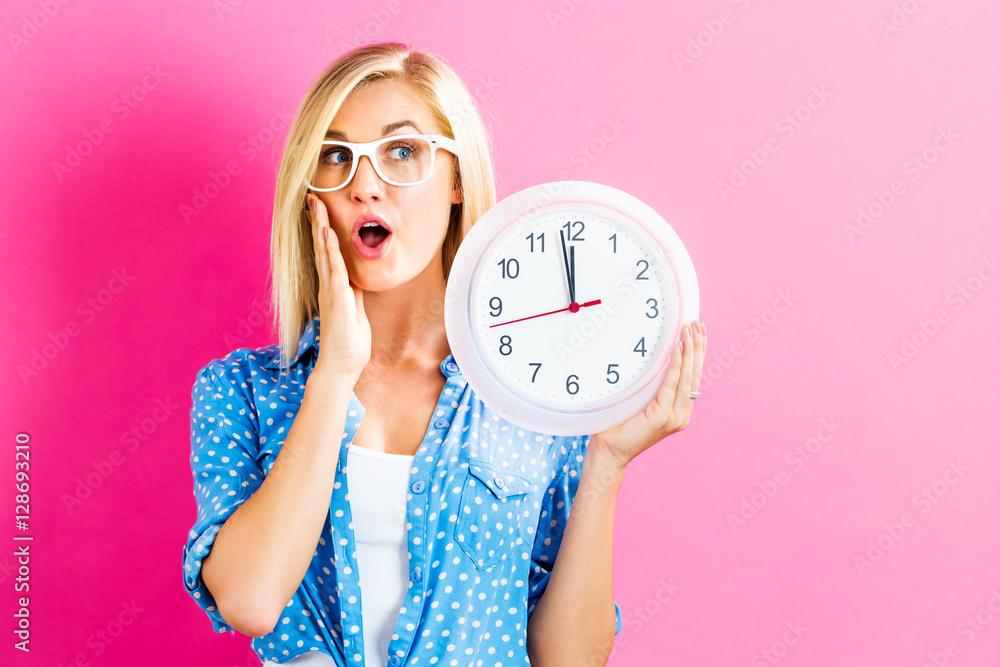 Woman holding clock showing nearly 12