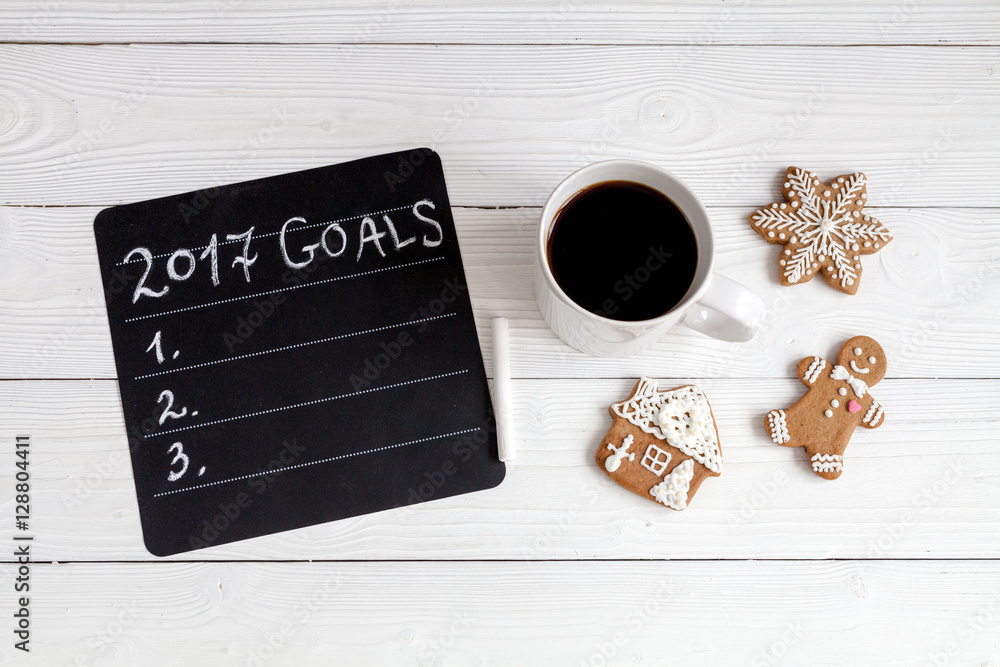 notebook and goals for new year wooden background top view