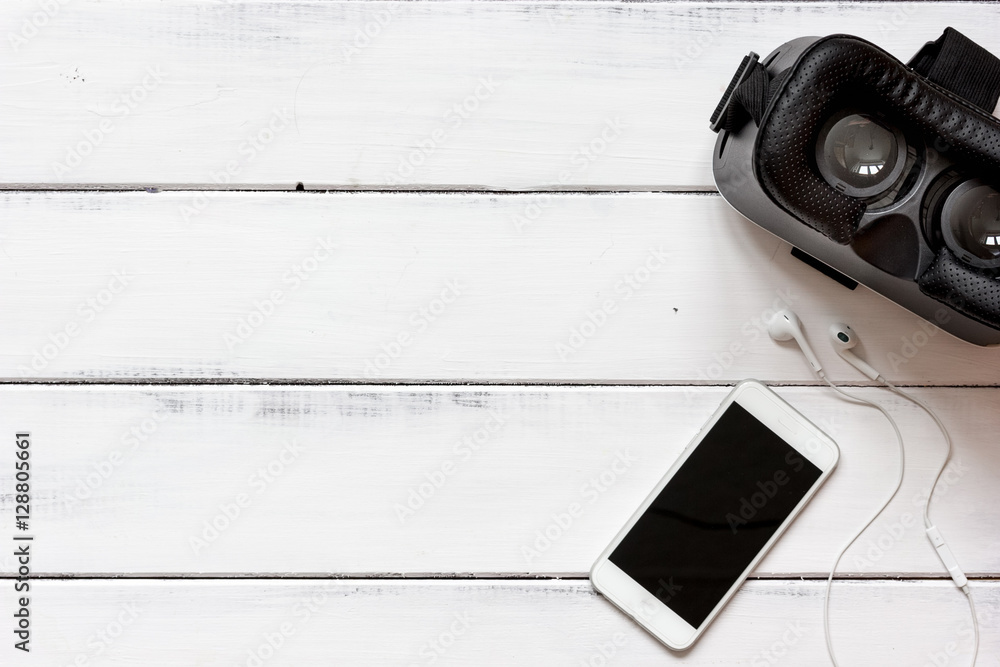 virtual reality glasses with smartphone on wooden background