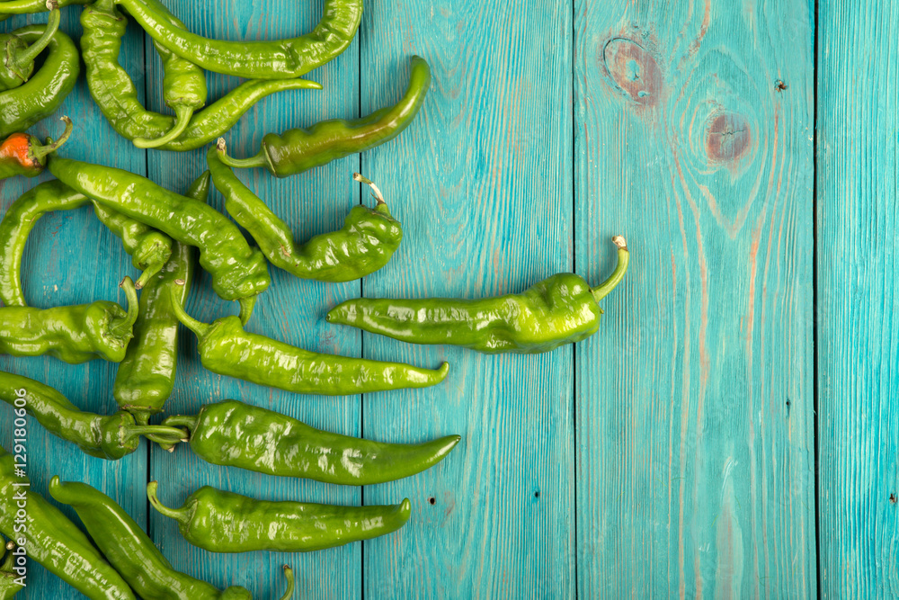 green pepperoni peppers on the wooden table