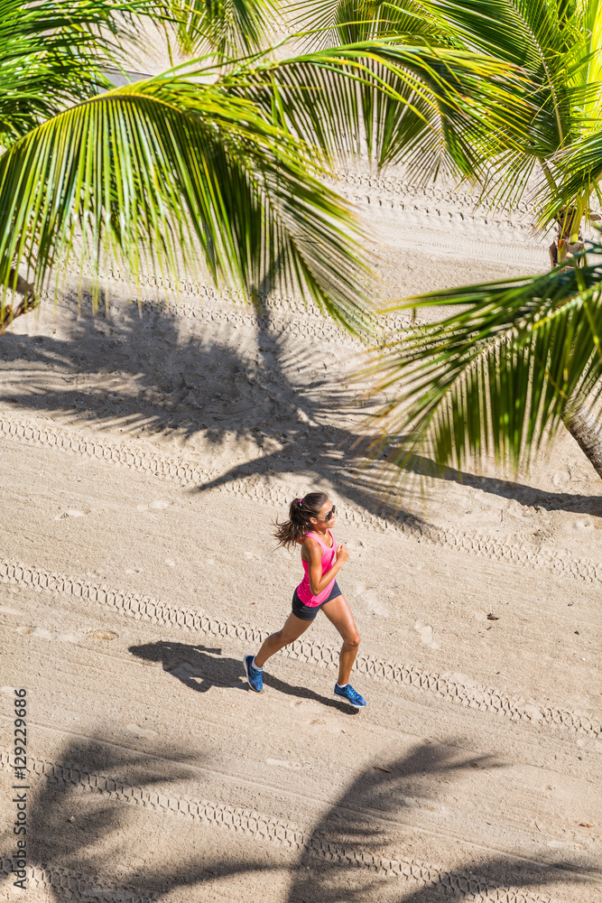 Healthy active lifestyle sport woman running doing exercise workout on tropical beach in between pal