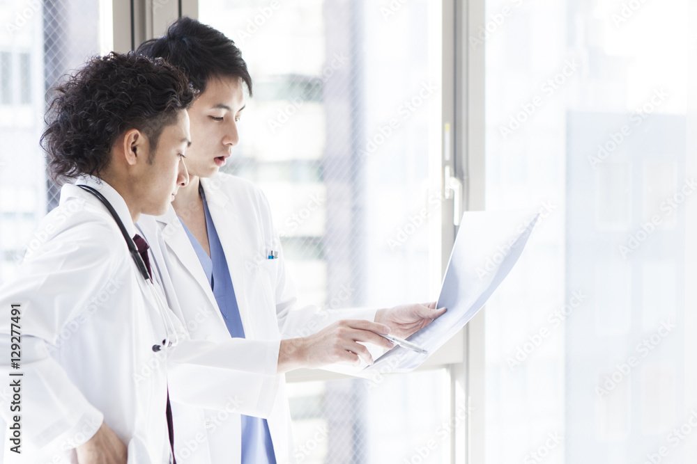 Doctors are talking while watching an X - ray picture at a hospital