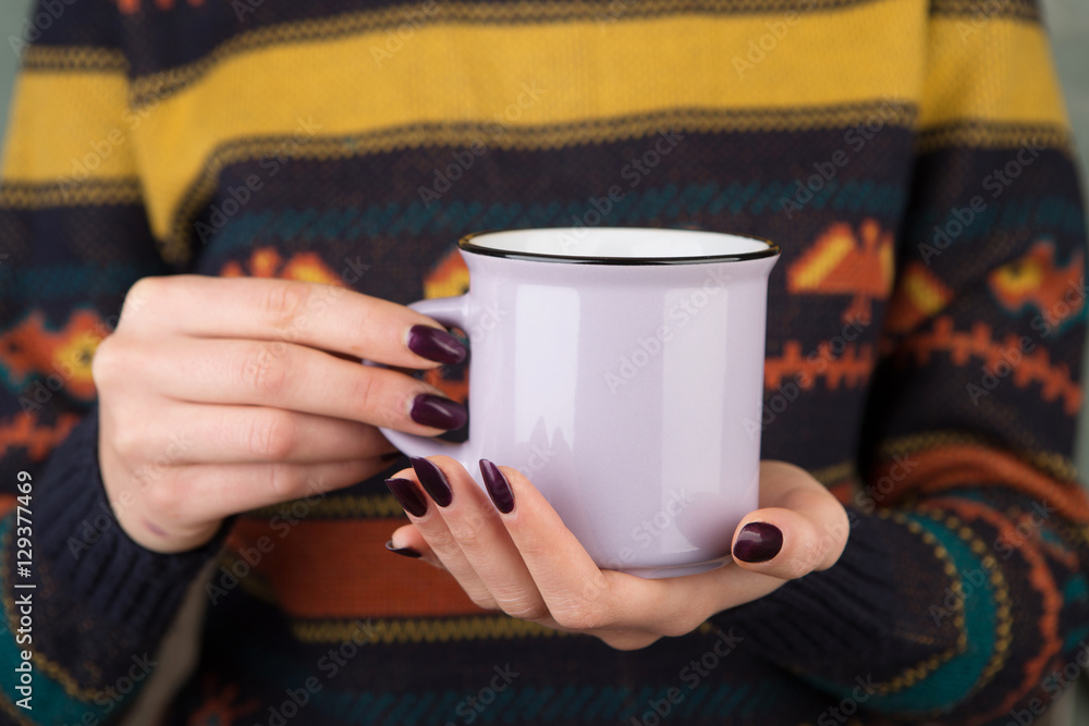 Woman in cozy sweater holding a cup