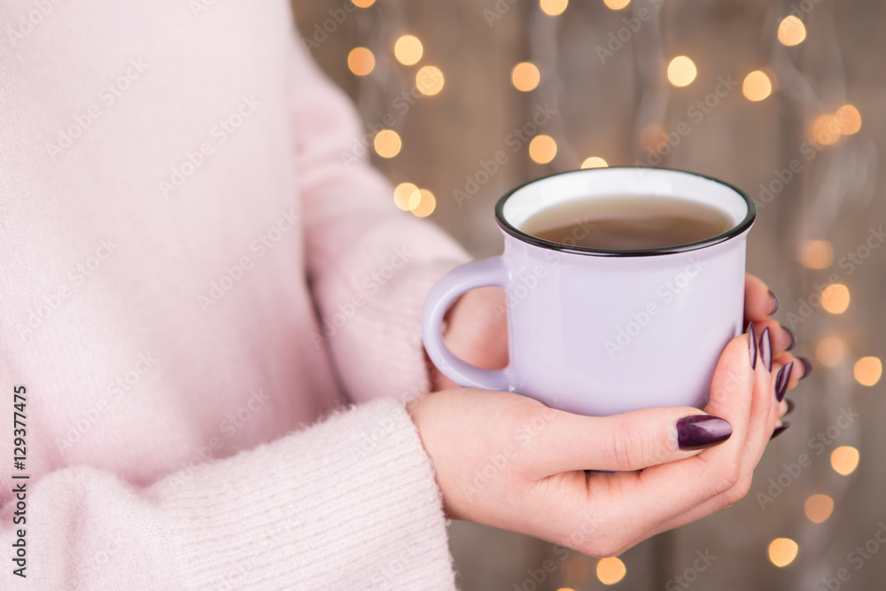 Woman in cozy sweater holding a cup