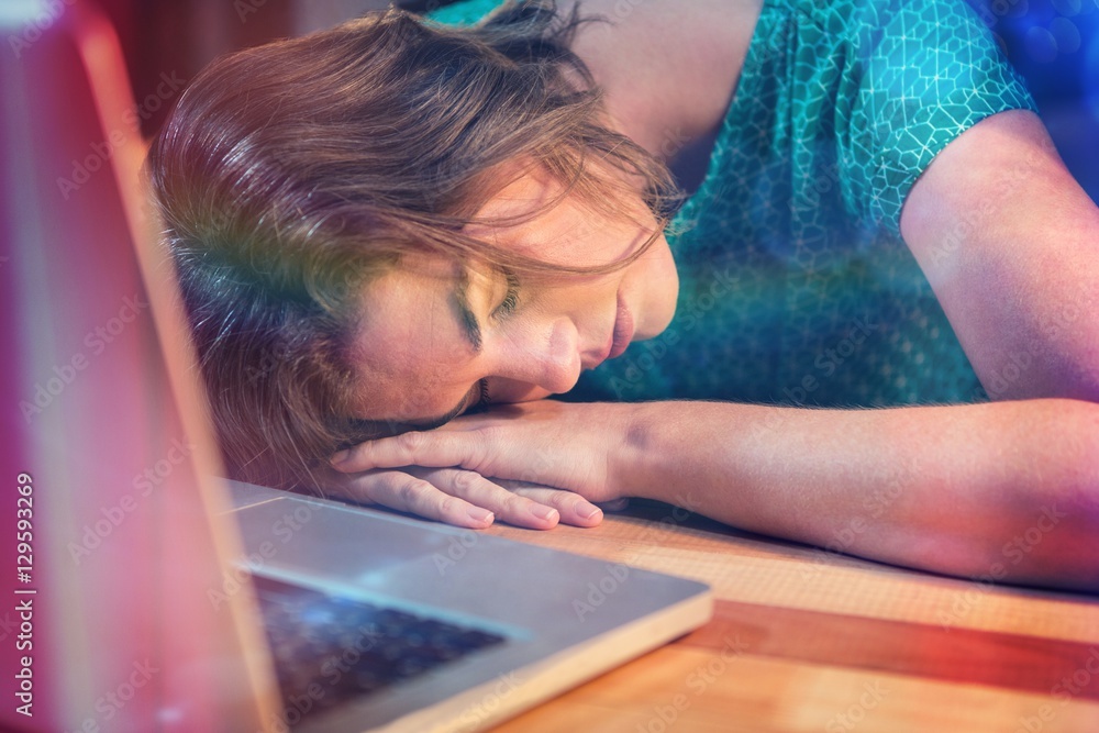 Tired businesswoman sleeping at desk