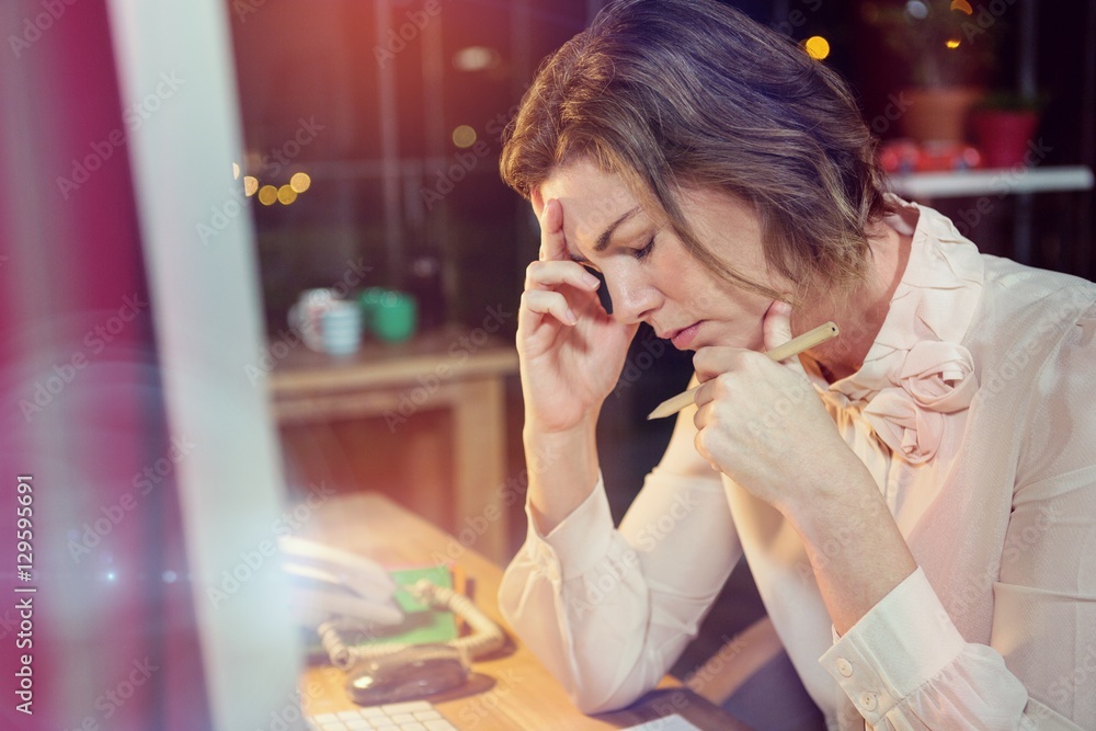 Stressed businesswoman sitting at `desk