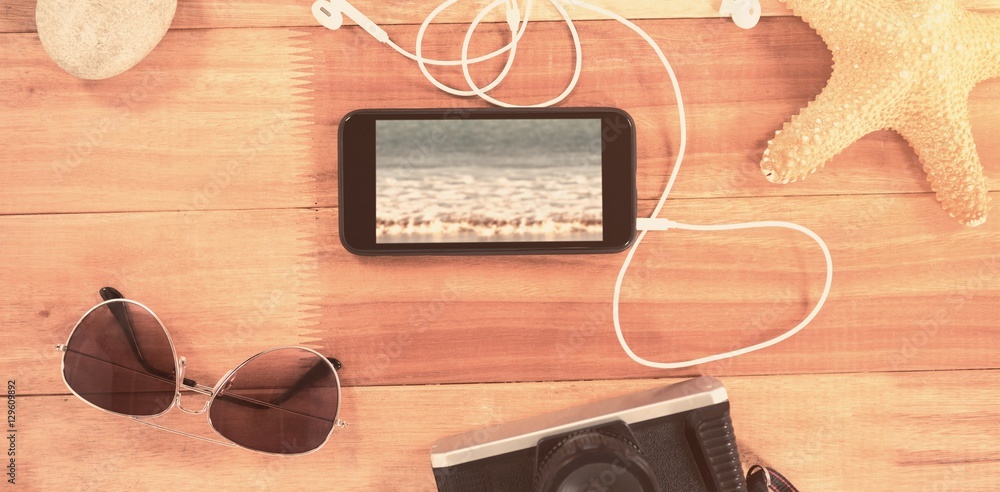 Composite image of beach accessories on wooden board