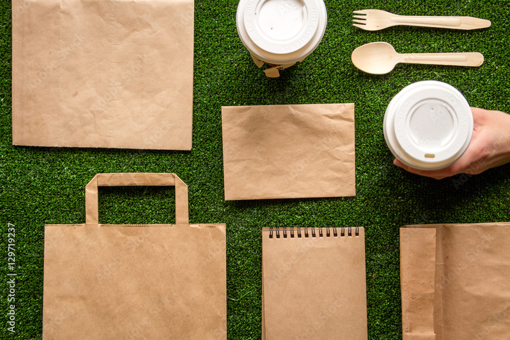 take out in paper bag on green background top view