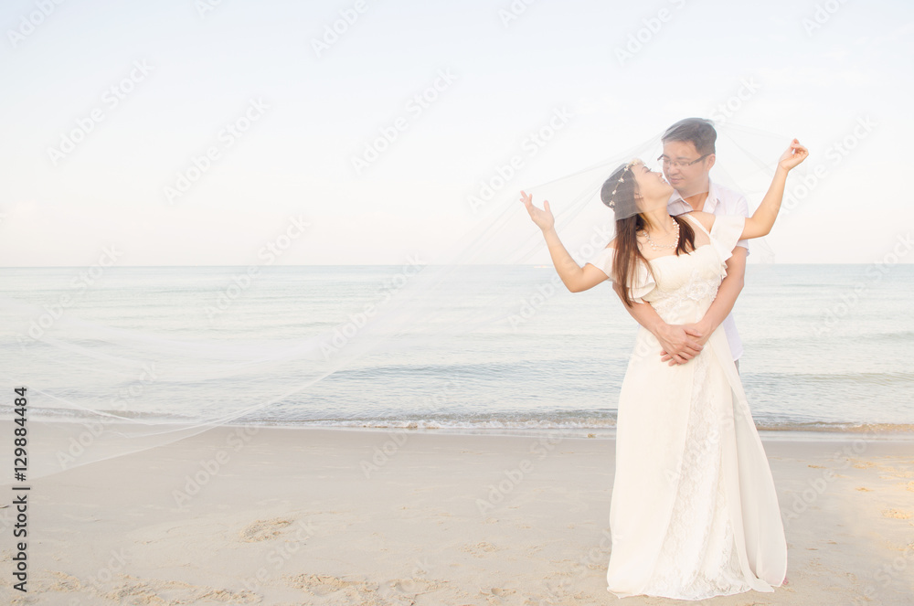 Outdoor Bride and groom on the beach  in the evening.