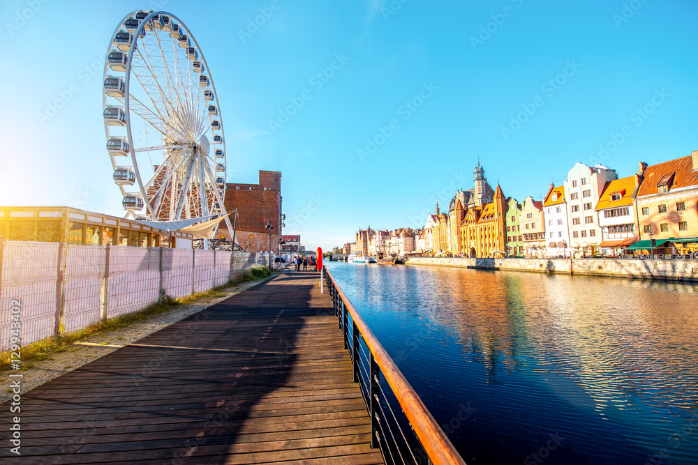 Morning view on the riverside of Motlawa river with beautiful buildings and viepoint wheel in the ol