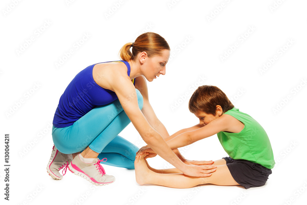 Female trainer teaching kid boy stretching legs