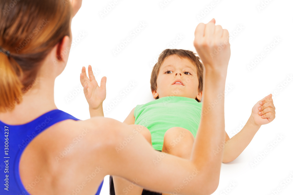 Kid boy doing exercises with female trainer