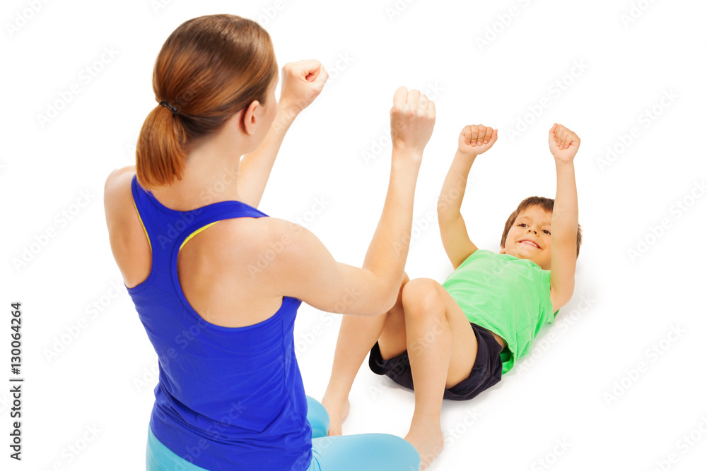 Smiling boy doing exercises with female trainer