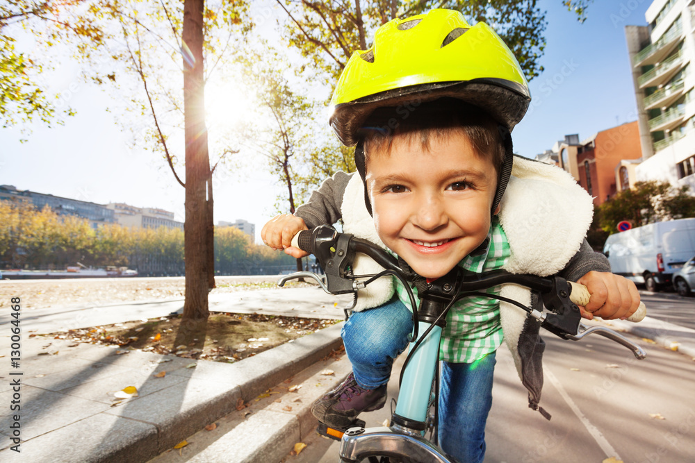 Smiling boy in safety helmet riding his bike