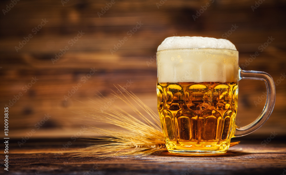 Glass of lager served on old wooden planks,