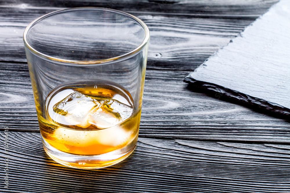 glass of whiskey on dark wooden background