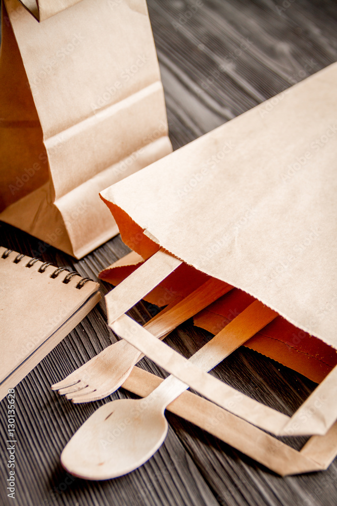 cup coffee and bread in paper bag on wooden background