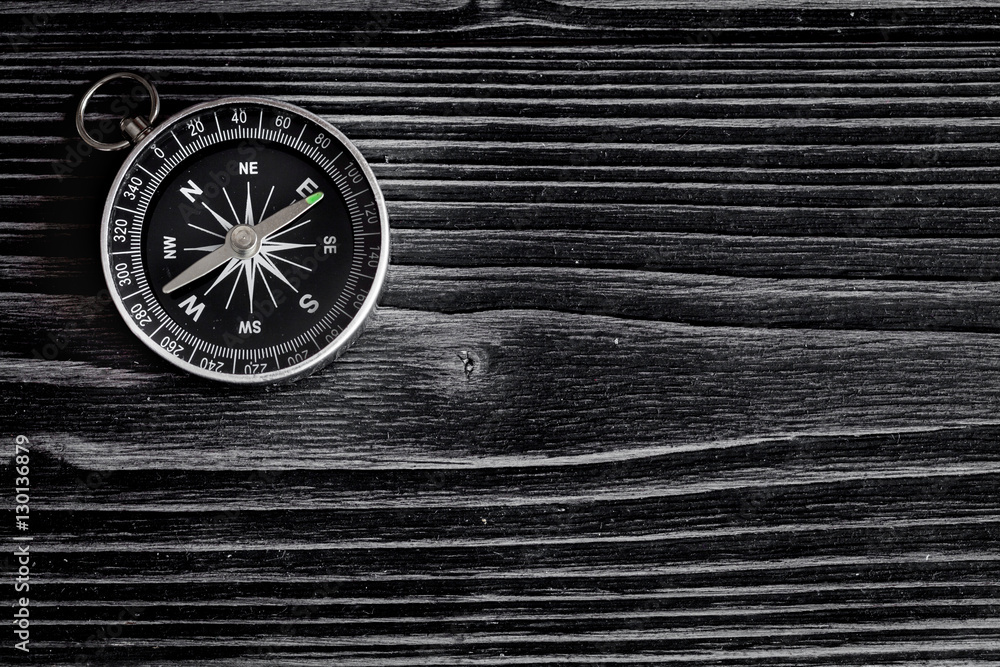 compass on dark wooden background concept direction motion top view