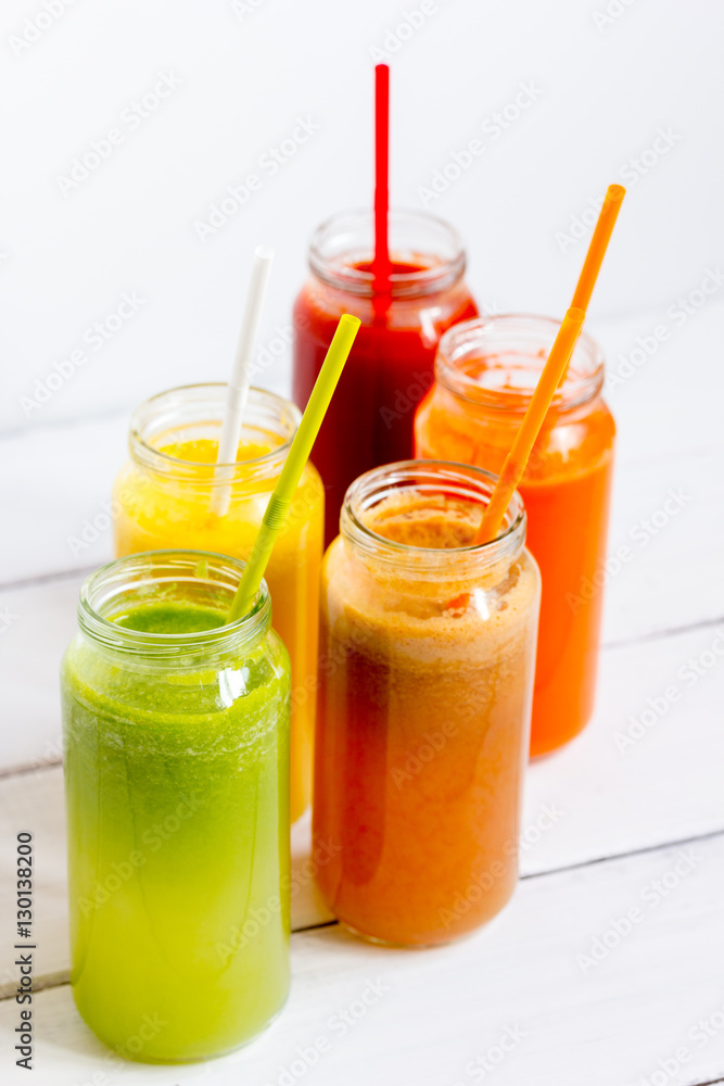 Fresh detox juices in glass bottles on white background