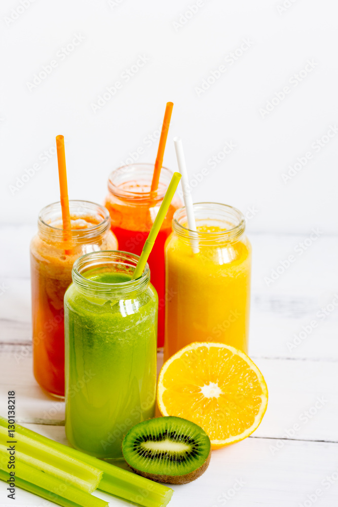 Fresh detox juices in glass bottles on white background