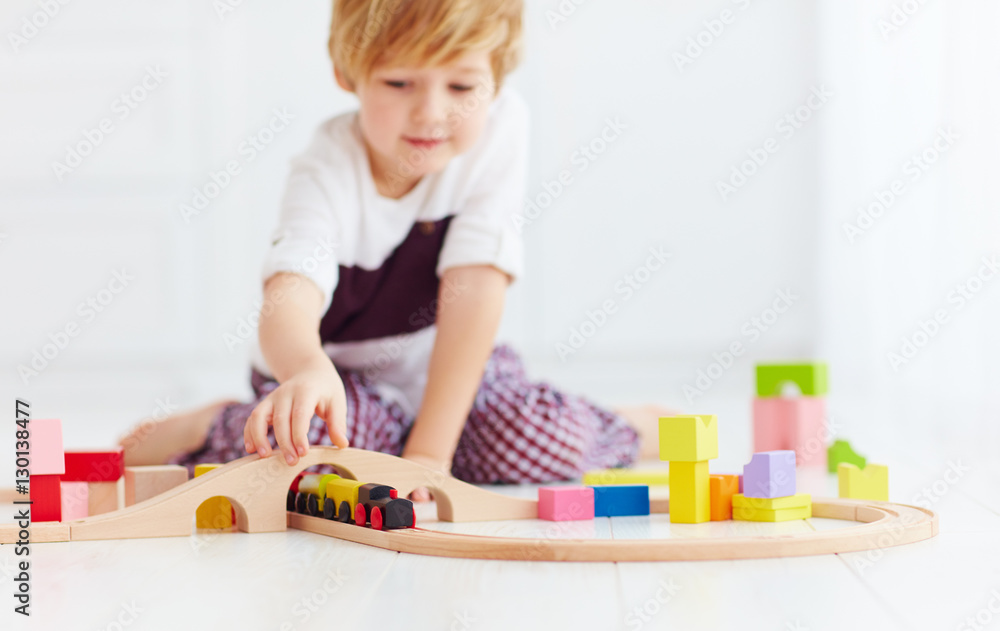 cute kids playing with toy railway road at home. focus on train