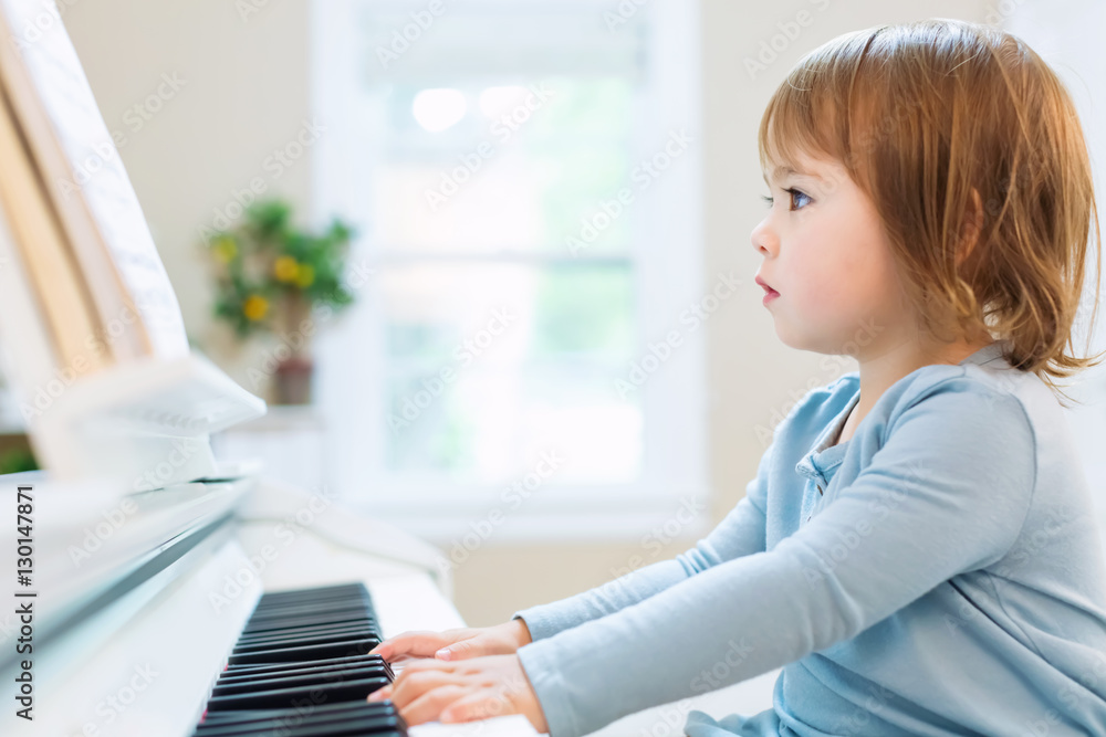 Toddler girl playing piano