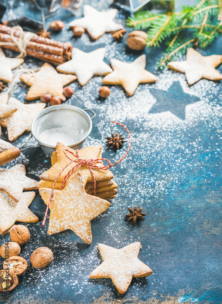 Gingerbread Christmas star shaped cookies with cinnamon, anise and nuts served with fir-tree branch 