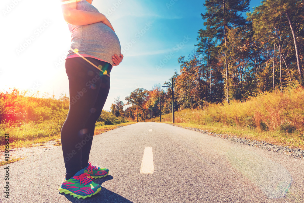 Fit pregnant woman standing outdoors